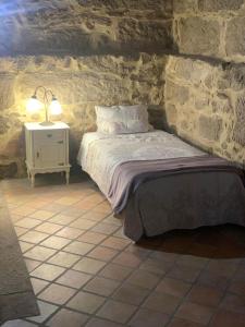 a bedroom with a bed and a table with a lamp at Vila Margarida in Porreiras +26 photos