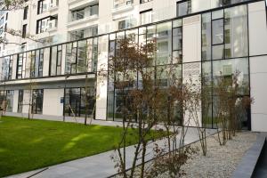 un bâtiment doté de fenêtres en verre sur son côté dans l'établissement Brown I One Bedroom Apartment I One Cotroceni Park, à Bucarest