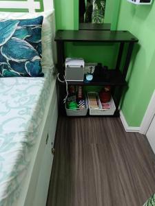 a small bed with a night stand next to a bed at Uncle's Tagaytay Staycation in Iruhin