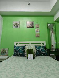 a bedroom with a bed with a green wall at Uncle's Tagaytay Staycation in Iruhin