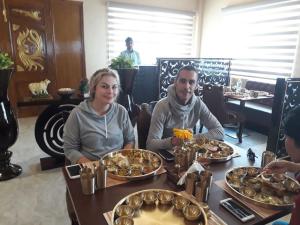 a man and woman sitting at a table with food at jyoti dormitory in Varanasi +4 photos