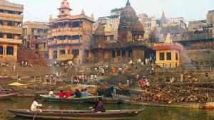 a group of people in boats in the water in a city at jyoti dormitory in Varanasi