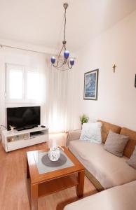 a living room with a couch and a tv at Apartment Beky in Podstrana