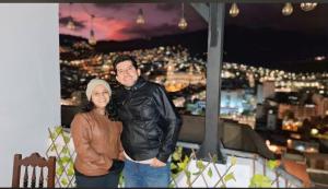 a man and a woman standing on top of a building at Hostal La Terraza - Roof Terrace Overlooking The North and Historic Centre in Quito