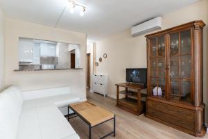 un soggiorno con divano bianco e mobile in legno di Golden Sunset a Benalmádena