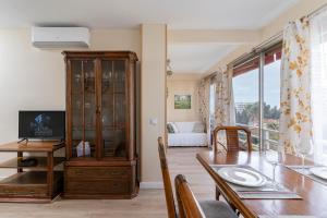 una sala da pranzo con tavolo e un centro di intrattenimento di Golden Sunset a Benalmádena