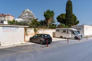 un'auto parcheggiata in un parcheggio accanto a un rimorchio di Golden Sunset a Benalmádena