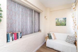 un soggiorno con finestra e divano di Golden Sunset a Benalmádena Altre 28 foto