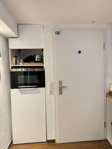 a kitchen with a white refrigerator and an open door at Schöne Souterrain Wohnung in Herzogenrath mit Sauna! in Herzogenrath +12 photos