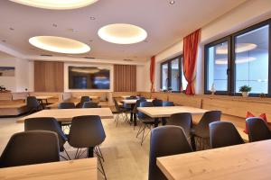 a restaurant with tables and chairs and windows at Jugendpension Müllauerhof in Saalbach Hinterglemm