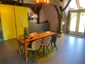 a kitchen with a wooden dining table and chairs at 't Hof van Wespert in Westdorp +22 photos