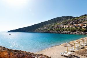 a beach that has some boats on it at Daios Cove Luxury Resort & Villas in Agios Nikolaos