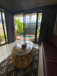 Una sala de estar con un sofá y una mesa de café. en Villa Aer Uluwatu, en Uluwatu
