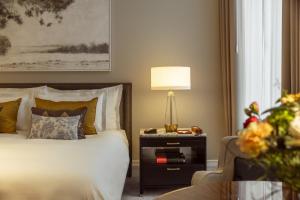 a bedroom with a bed and a table with a lamp at Corinthia Grand Hotel Astoria Brussels in Brussels
