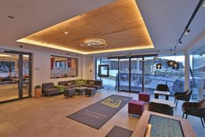 a large lobby with chairs and tables in a building at Jugendpension Müllauerhof in Saalbach Hinterglemm