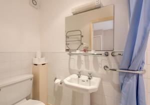 une salle de bain avec un lavabo, des toilettes et un miroir dans l'établissement Luffness Castle Cottage, à Aberlady 23 autres photos