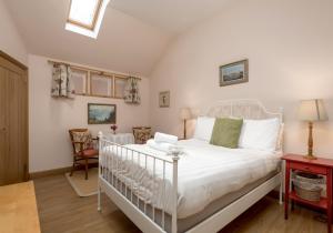 une chambre avec un lit blanc dans une pièce dans l'établissement Luffness Castle Cottage, à Aberlady