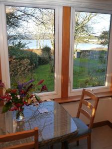 une salle à manger avec une table en verre et une fenêtre dans l'établissement Calluna Cottage, à Rockcliffe