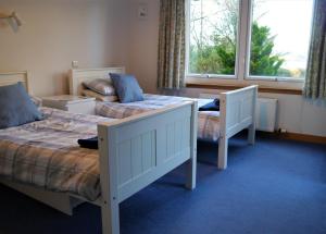 une chambre avec deux lits et une fenêtre dans l'établissement Calluna Cottage, à Rockcliffe