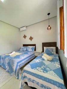 two beds sitting next to each other in a room at Casa de Temporada Estrela de Alter in Santarém +39 photos