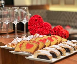 a table with two plates of cakes and wine glasses at EST Grand Hotel Savoy in Budapest