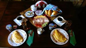 a table with plates of breakfast food on it at Apartamenty Smętek in Ełk