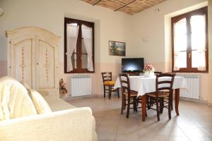 un soggiorno con tavolo, sedie e TV di Appartamenti La Rosetta a Magione