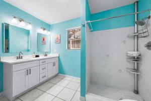 a bathroom with blue walls and a sink and a shower at Living the Dream By Beachside Management in Siesta Key +62 photos