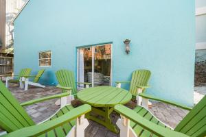 a green table and chairs on a patio at Living the Dream By Beachside Management in Siesta Key