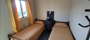 a small room with two beds and a window at Habitaciones en Zona Céntrica in Tarija