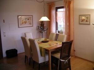 a dining room table with white chairs and a dining room at Ferienwohnung Meier in Kressbronn am Bodensee