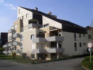 a large white building with balconies on a street at Ferienwohnung Meier in Kressbronn am Bodensee