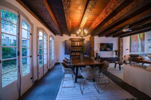 a dining room with a table and chairs and windows at Casa Odara Paraty in Paraty