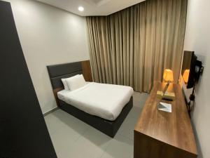 科威特Saray Prime Suites的酒店客房设有一张床和一张木桌