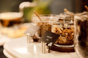 a table topped with jars of food with nuts at Radisson Blu Hotel, Madrid Prado in Madrid