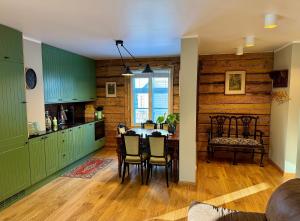 a kitchen with green cabinets and a table with chairs at Veski Apartment in Kuressaare