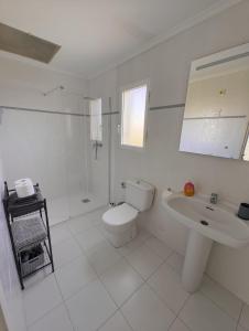 a white bathroom with a toilet and a sink at Studio tipo Loft con vista al Montgo in Denia +25 photos