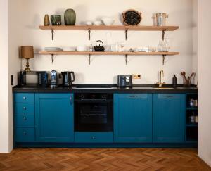 a kitchen with blue cabinets and black counter tops at 1 bedroom apartment in central Munich in Munich +13 photos
