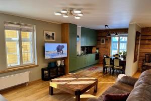 a living room with a couch and a table and a kitchen at Veski Apartment in Kuressaare