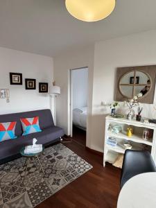 a living room with a blue couch and a bedroom at Toulouse Marengo-Gare Matabiau - Médiathèque-Allées Jean Jaurès proche ligne B Parking privé sécurisé gratuitprivé in Toulouse
