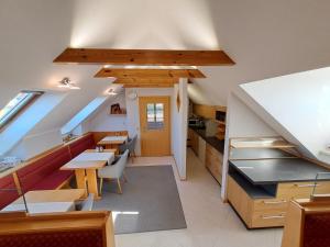 an attic kitchen and dining room with tables and chairs at Glatz Haus Siegesbrunn in Bad Waltersdorf