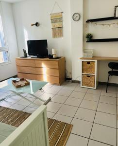 un soggiorno con tavolo in vetro e scrivania di Lou pitcho apartament ad Avignone Altre 4 foto