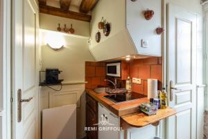 Una pequeña cocina con fregadero y microondas. en Les Colombages - studio ON the port of Honfleur - nice view, en Honfleur