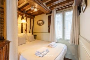Un dormitorio con una cama con toallas. en Les Colombages - studio ON the port of Honfleur - nice view, en Honfleur