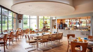 a restaurant with tables and chairs and a bar at Residhome Paris-Guyancourt in Guyancourt