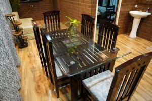 a dining room table with chairs and a glass table at Digaru Air House in Digru