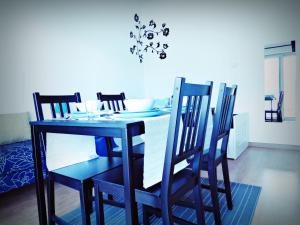 a dining room table with four chairs and a blue table and chairsktop at Residencia Praia Norte - AL in Nazaré