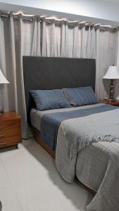 PampatarにあるExcelente full Equipado para 6 personasのベッドルーム1室(ヘッドボードとカーテン付きのベッド1台付)