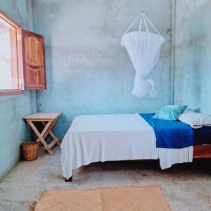 a small room with a bed and a table at El Cielo Hostel in Barra de la Cruz