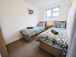 ein Schlafzimmer mit zwei Betten und einem Fenster in der Unterkunft South Fistral View Apartment in Newquay + 4 Fotos